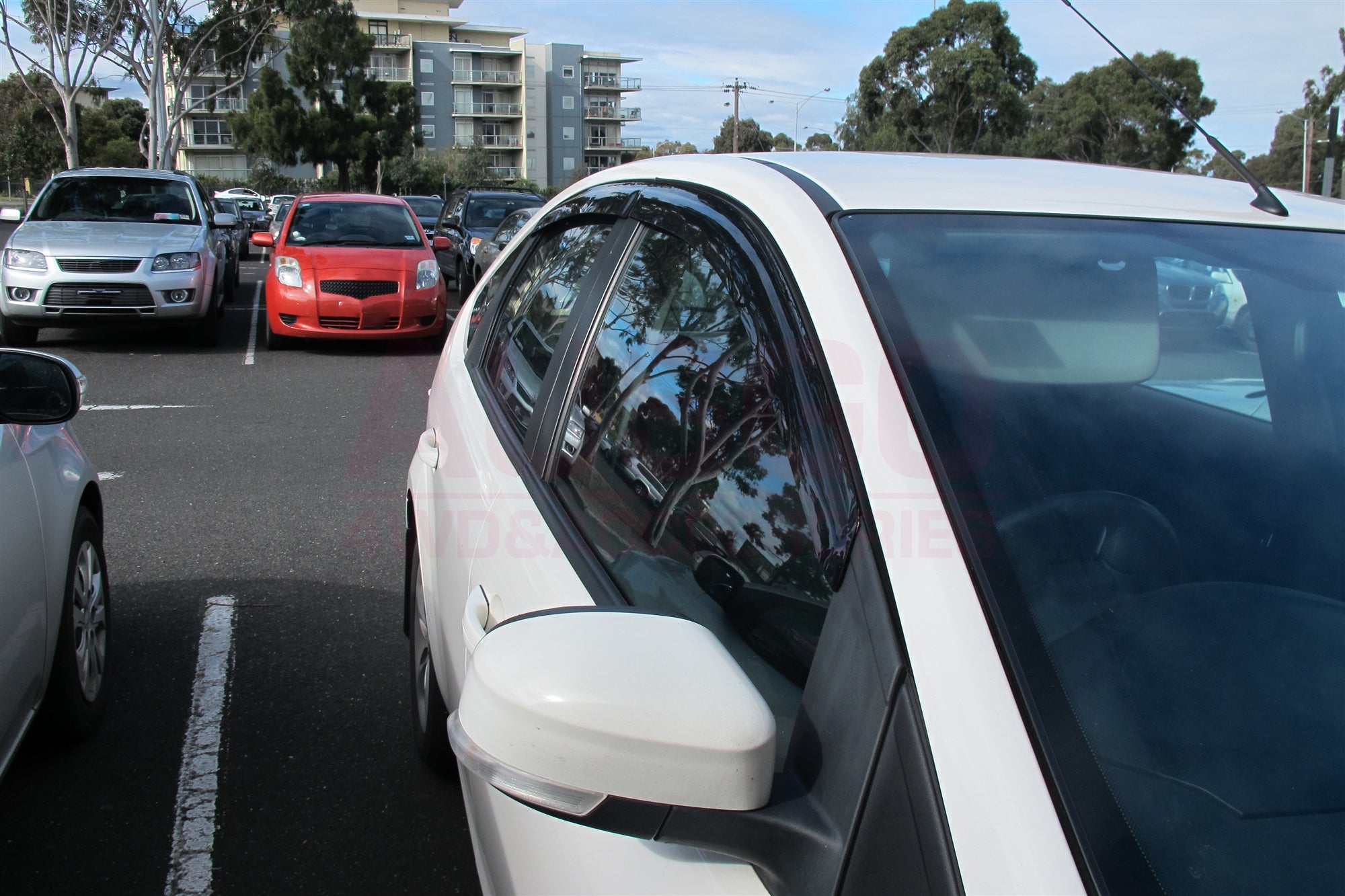 Side view of a white Ford Focus with weather shields attached to the windows.