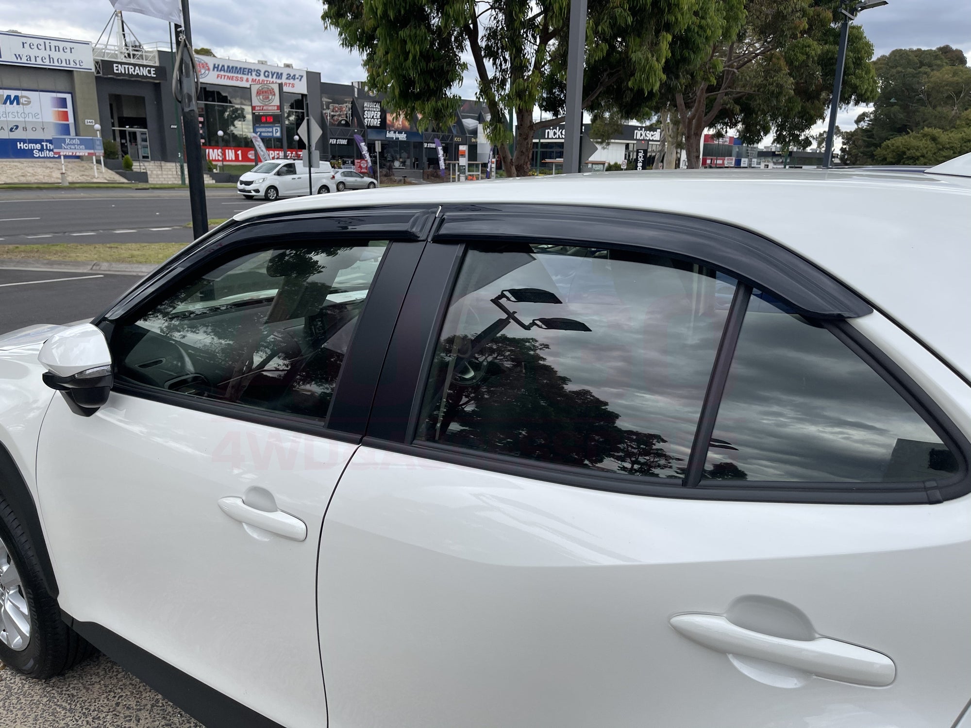 Side view of a white Yaris Cross parked in an outdoor carpark.