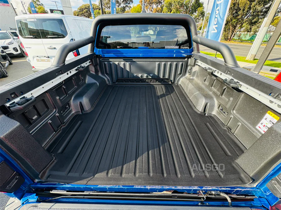 A black ute mat installed in the cargo area of a blue Ford Ranger