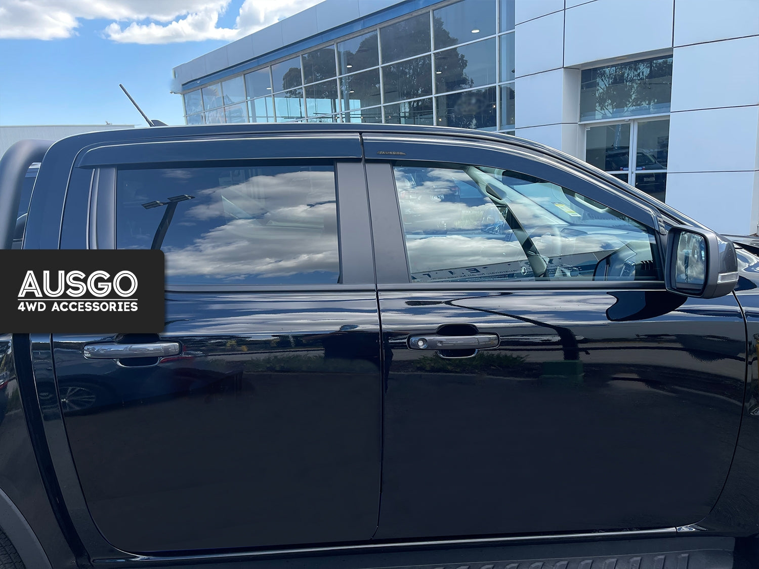 Side view of a black ute with weather shields installed on the windows