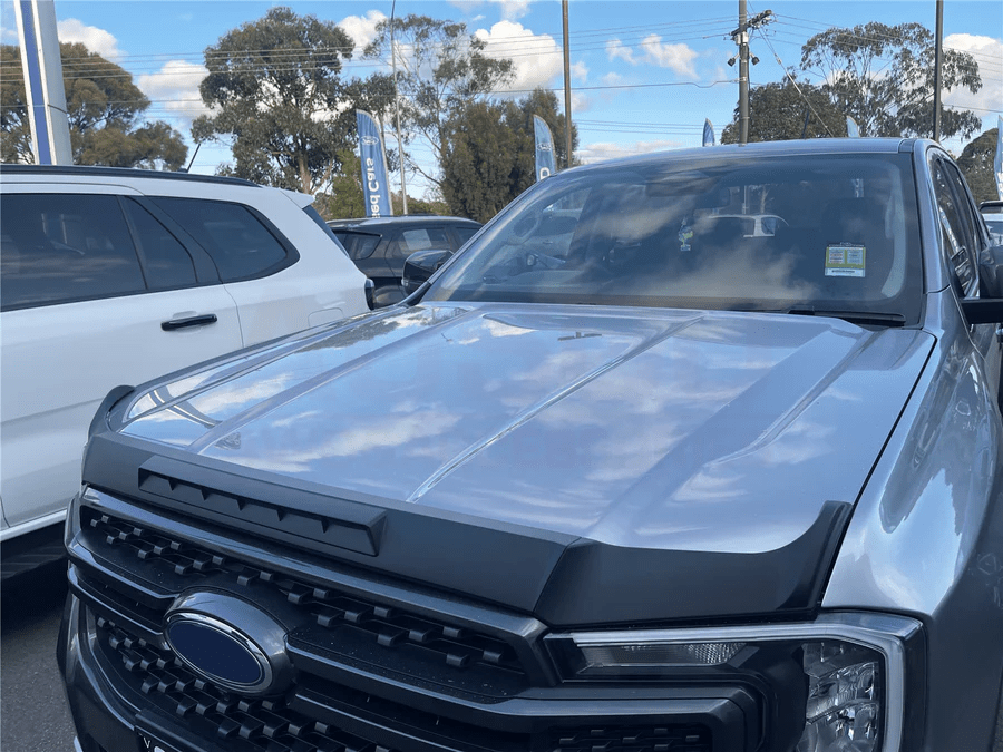 Close-up of a silver Ford Ranger with a sleek black bonnet protector installed, showcasing protection and style