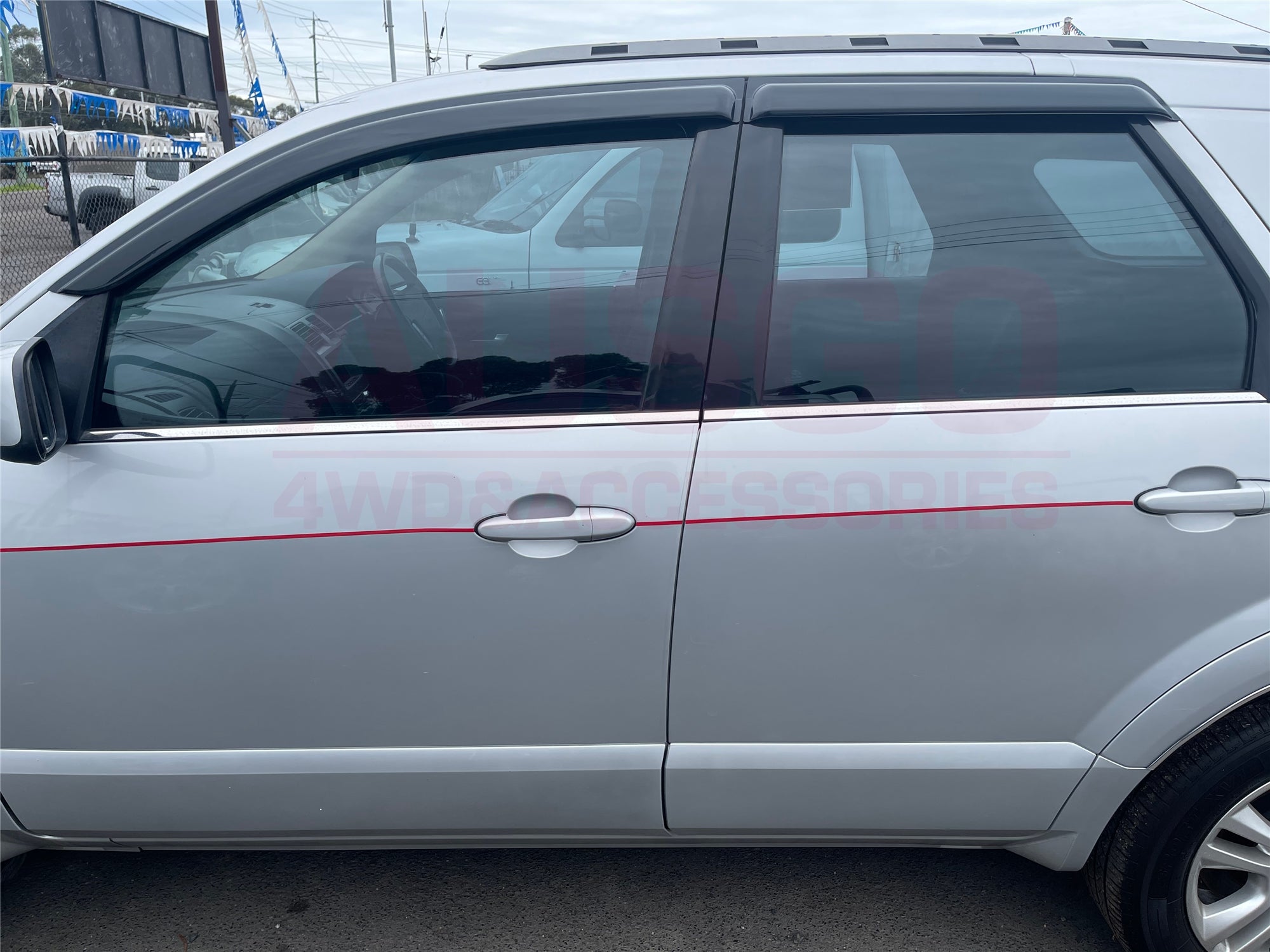 Side view of a grey Ford Territory with weather shields attached to the windows. 