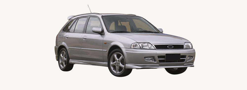 Side view of a silver Ford Laser parked in an outdoor area. 