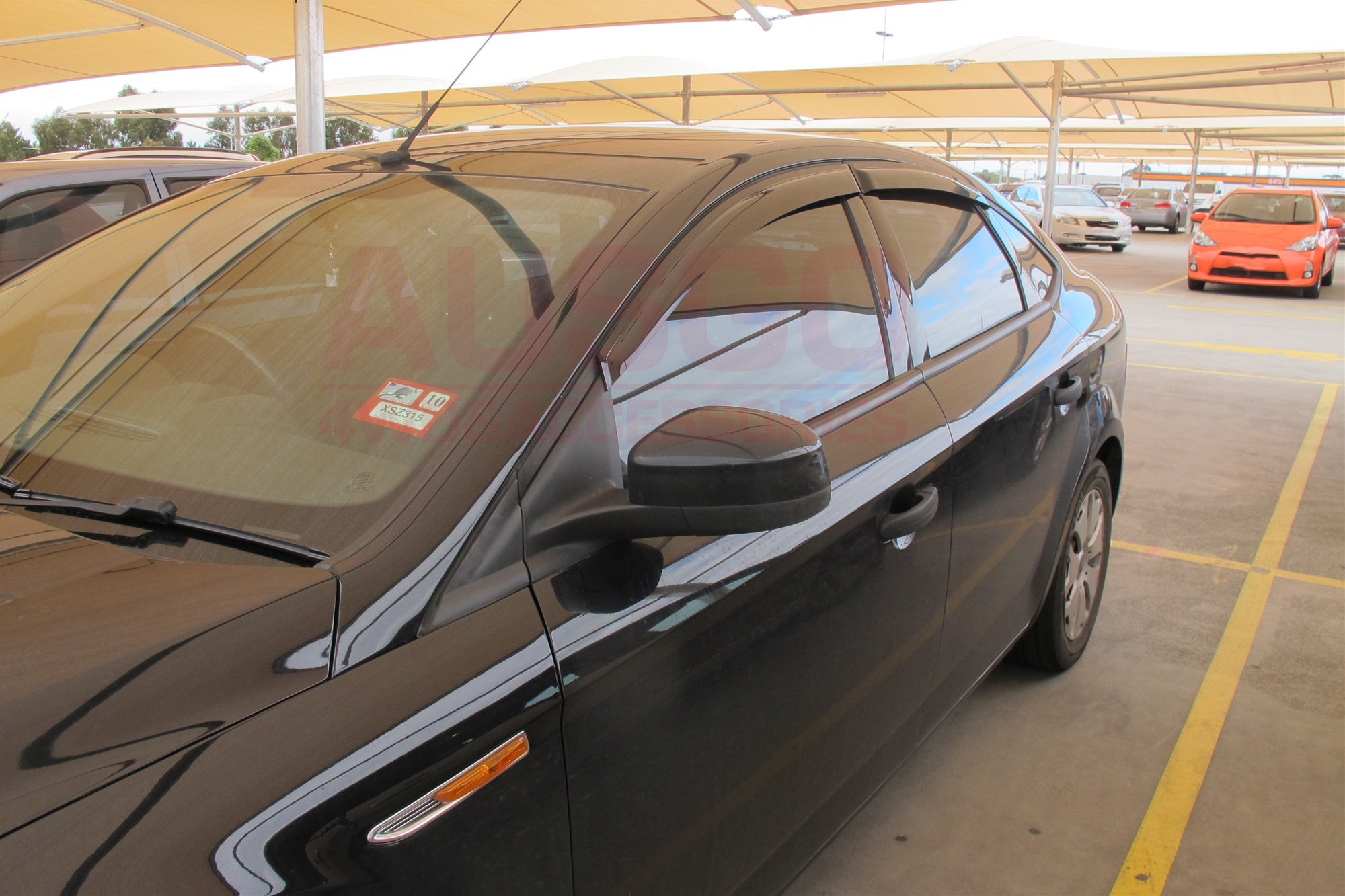 Side view of a black Ford Mondeo with weather shields attached to the car. 