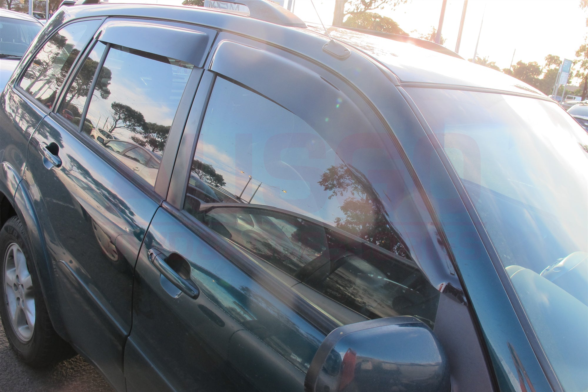 Side view of a black Toyota RAV4 with weather shields attached to the windows.