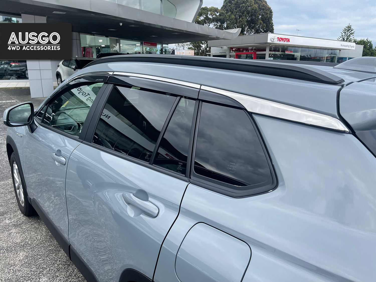Side view of a metallic blue Toyota Corolla Cross parked in an outdoor carpark.