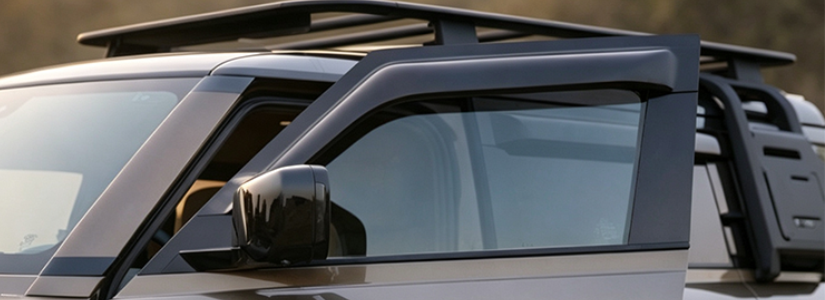 Weather shields attached to the windows of a white car.